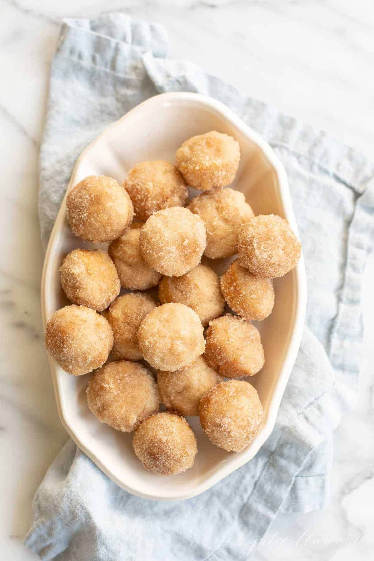 cinnamon muffins in serving dish on blue napkin