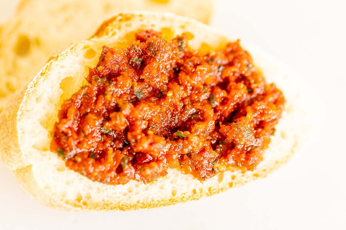 A crostini topped with sun dried tomato pesto