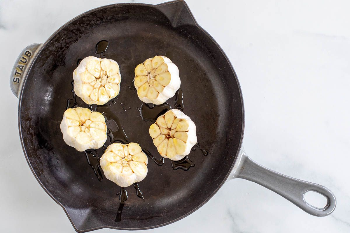 Five heads of garlic in a cast iron pan.