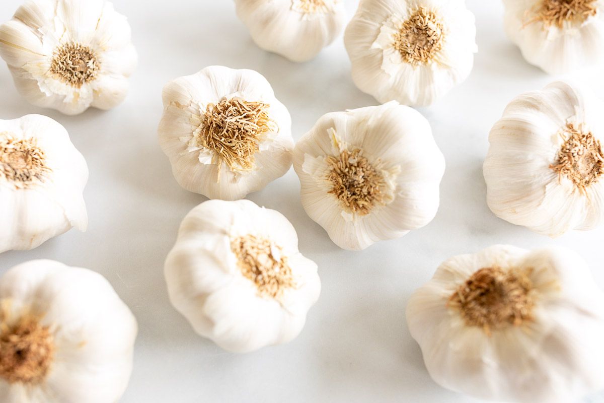 Garlic heads laid out on a marble countertop