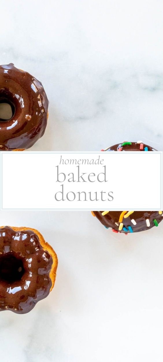 chocolate iced donuts laying on a white marble surface