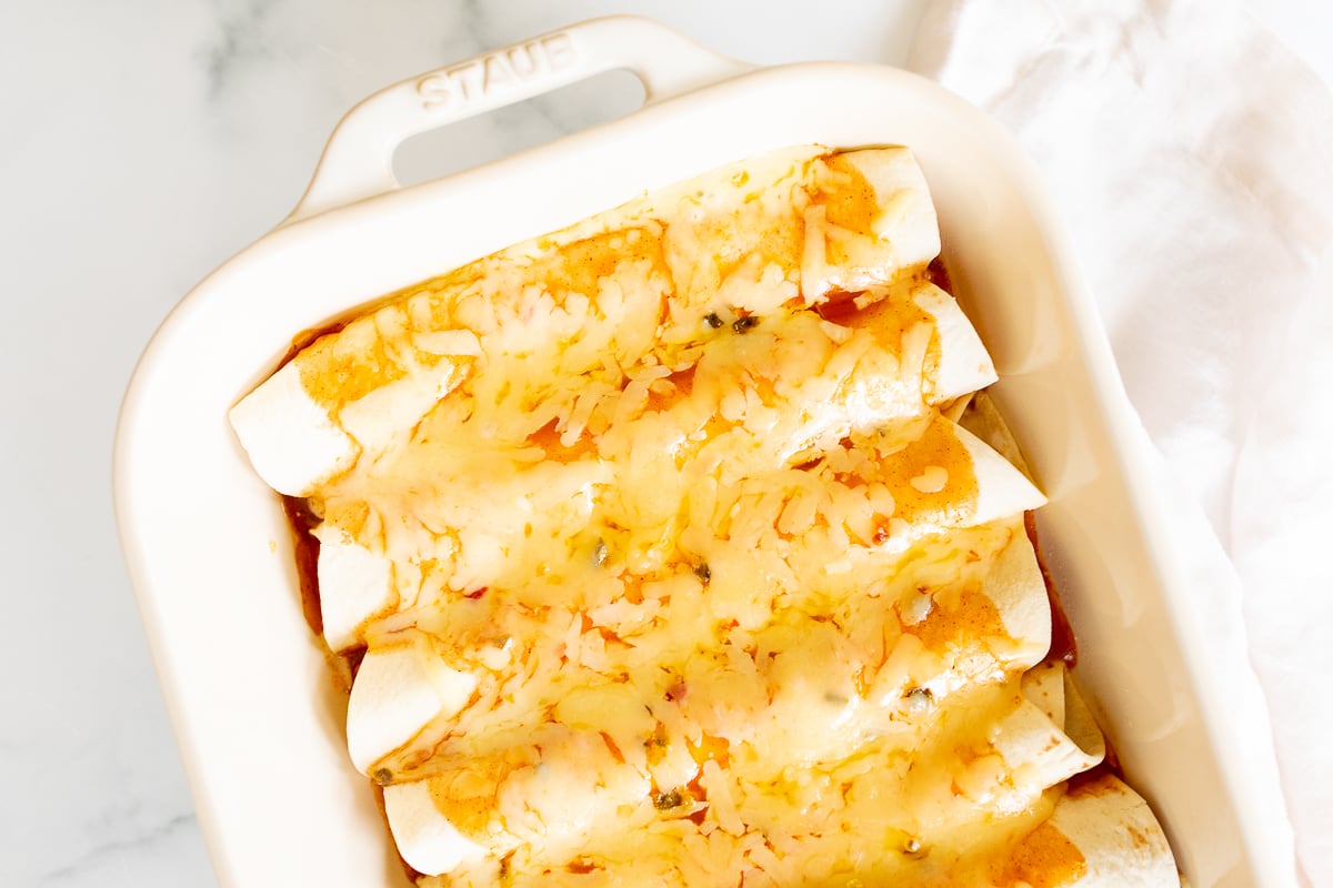 Cheese enchiladas in a white baking dish.