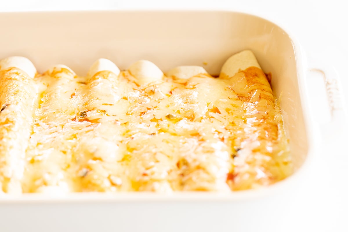 Cheese enchiladas in a white baking dish.