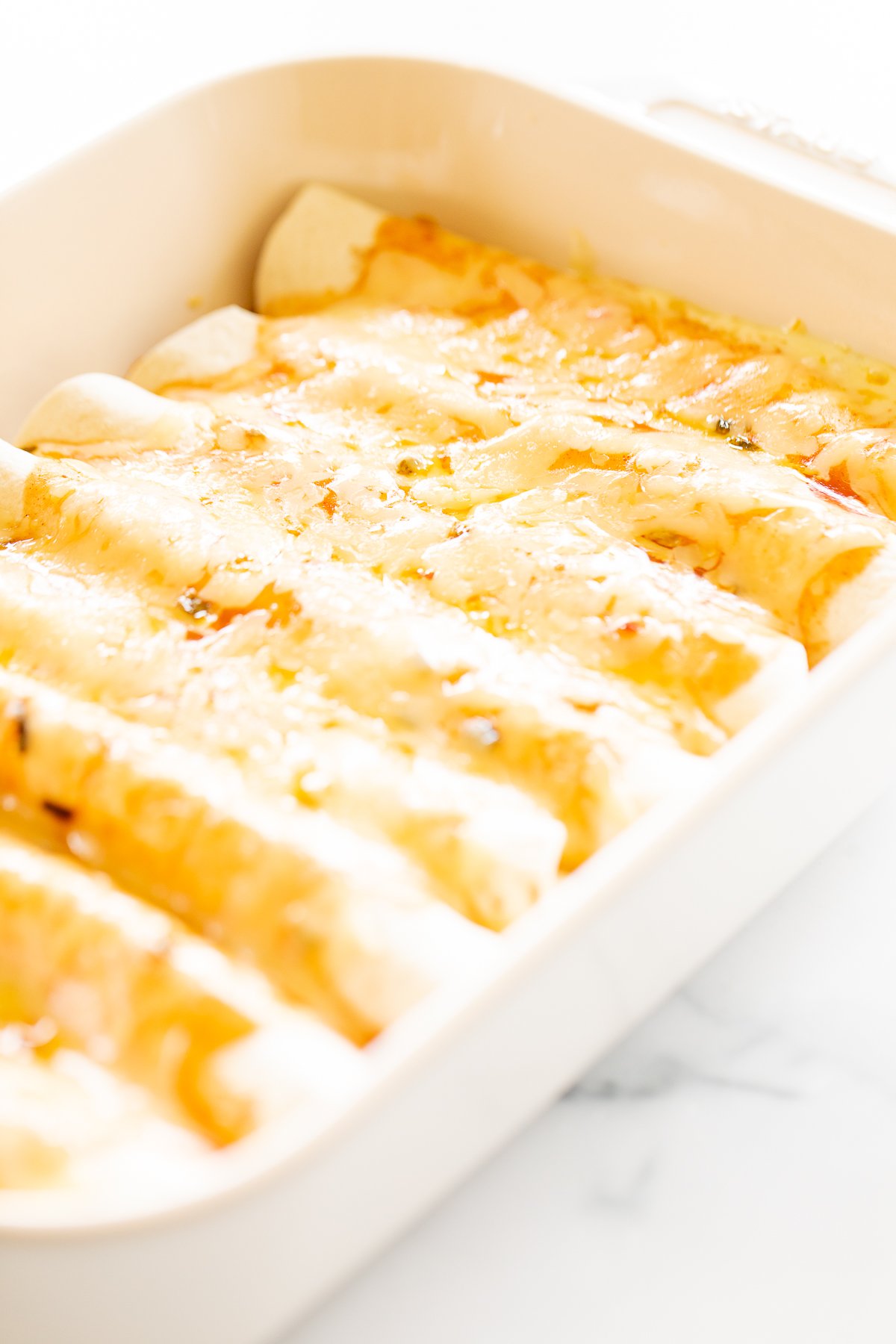 Cheese enchiladas in a white baking dish.