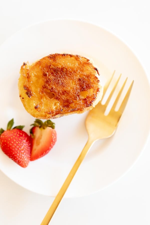 A serving of creme brulee french toast casserole on a white plate for Christmas brunch.