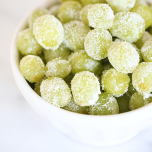 A white bowl of sugared prosecco grapes for a New Year's Eve Menu