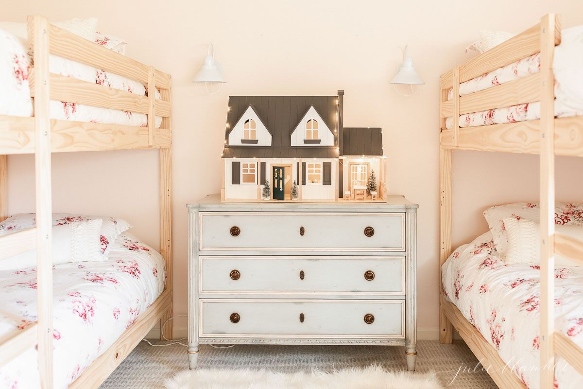 Girls bunk beds with floral bedding in a pink bedroom.