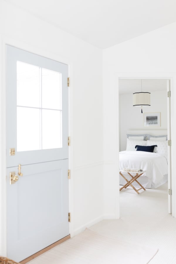 blue door white entry looking into bedroom