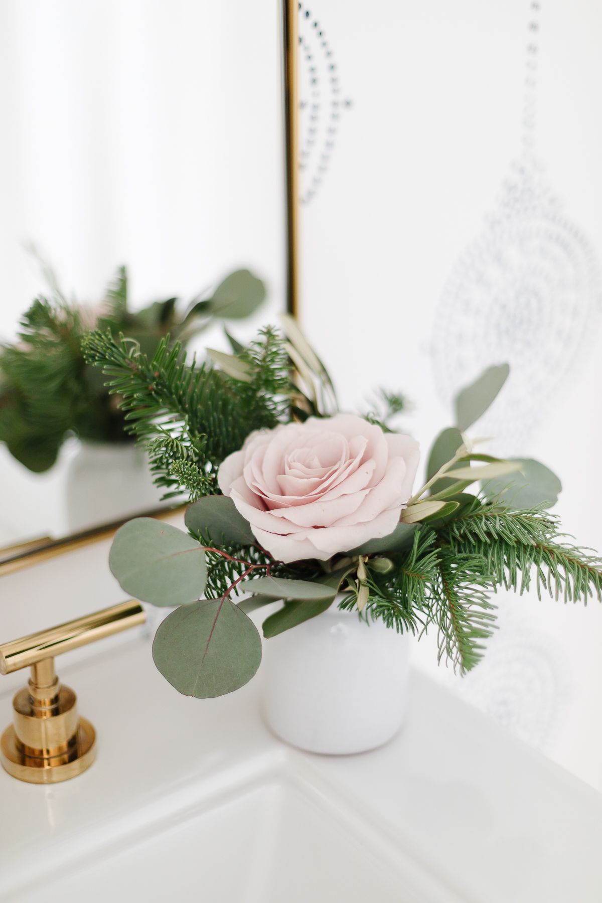 A modern bathroom with an amazon home vase with a pink rose