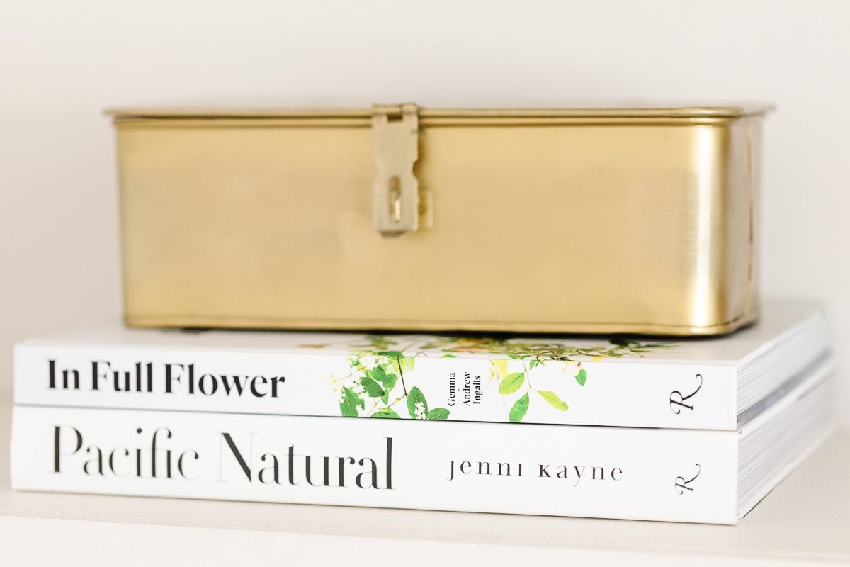 A brass box on top of two coffee table books