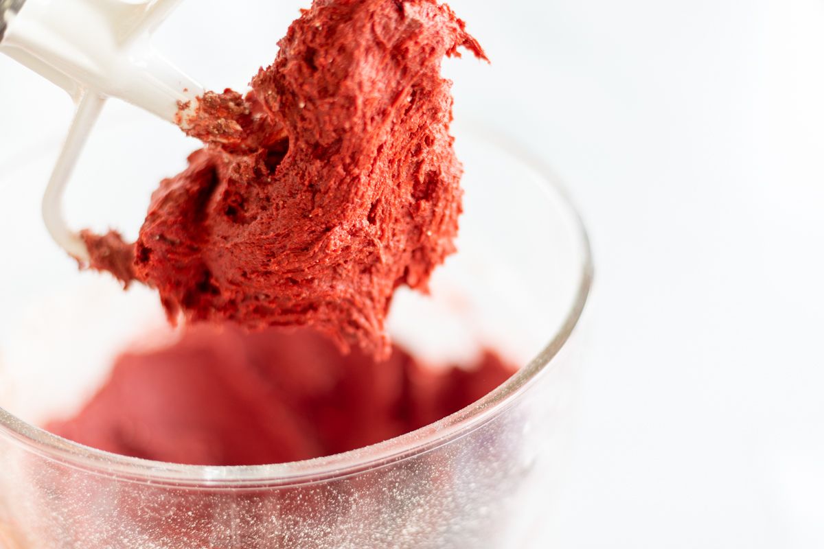 Red velvet gooey butter cookie dough in a glass mixing bowl.