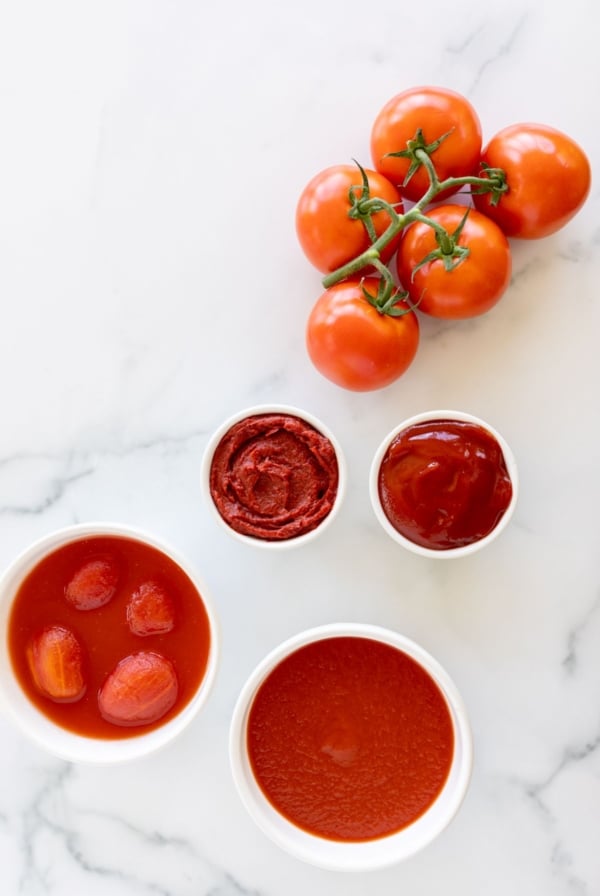 A variety of tomato paste substitutes placed on a marble countertop.