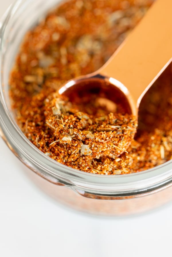 Closeup of measuring spoon scooping chipotle seasoning from jar