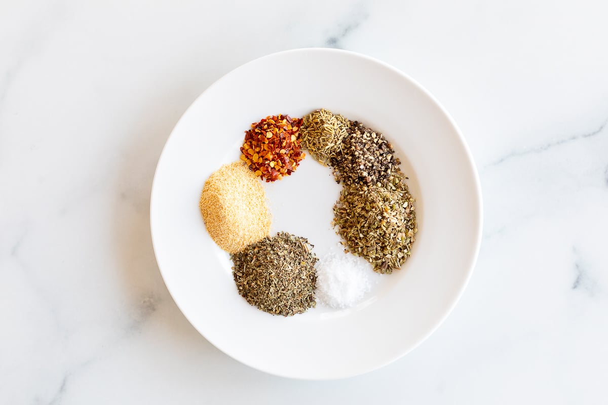 Overhead view of ingredients for oregano seasoning on plate