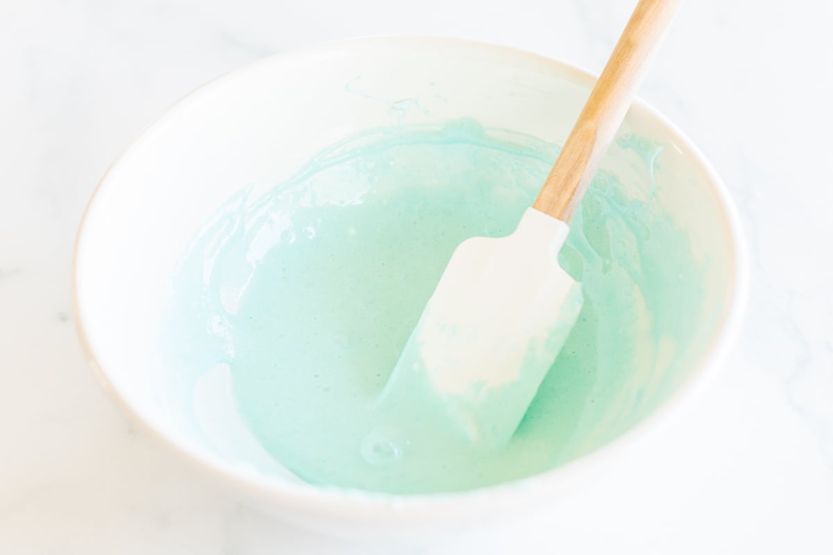 Blue marshmallow mixture in mixing bowl with rubber spatula