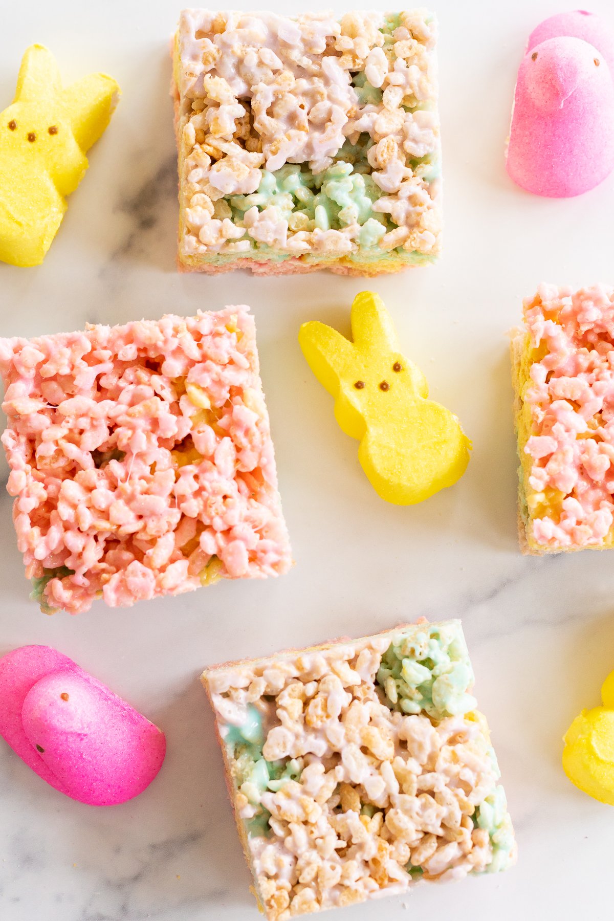 Overhead view of Peeps treats on marble countertop with yellow and pink Peeps