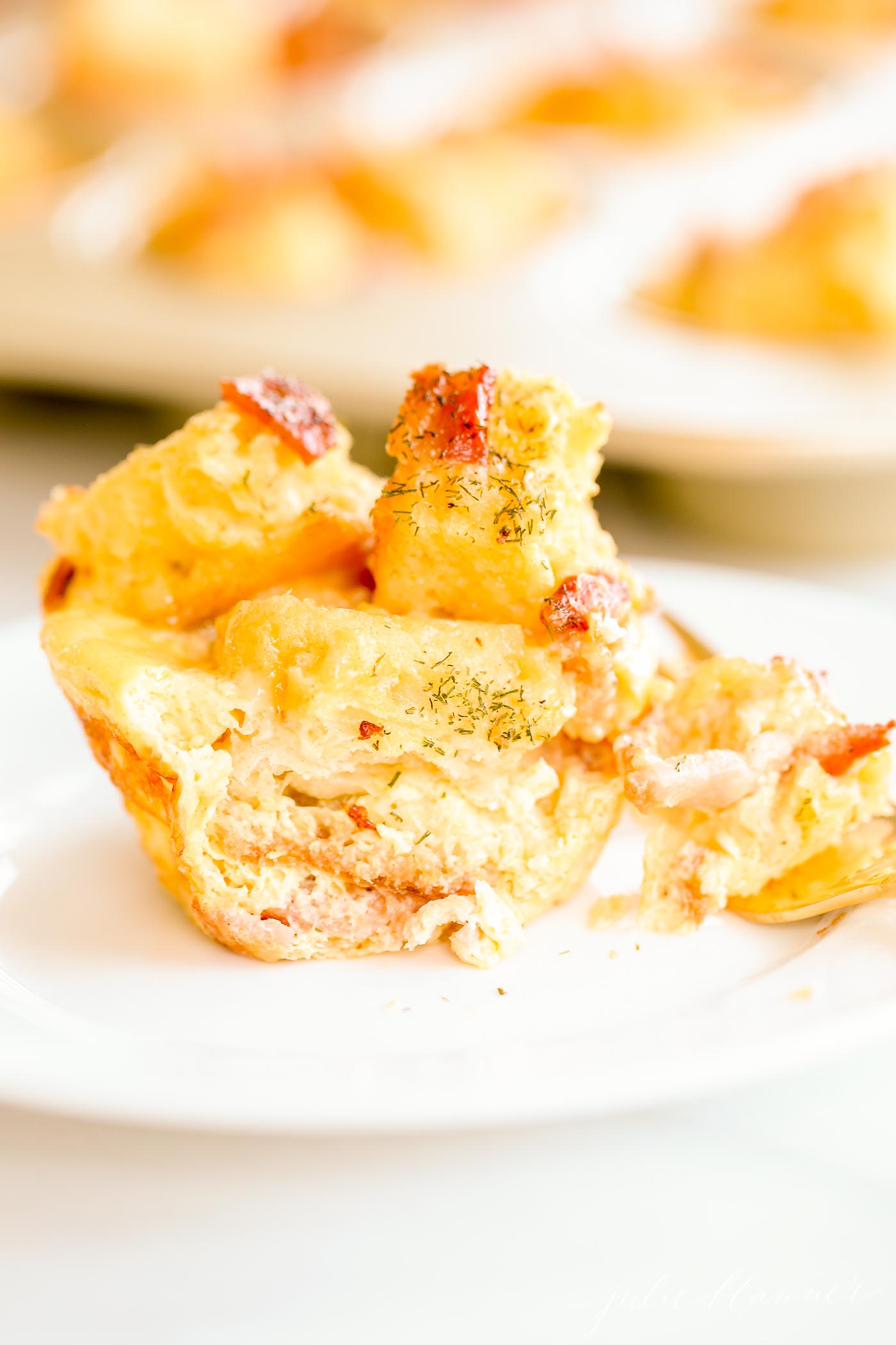 egg strata broken apart on a white plate