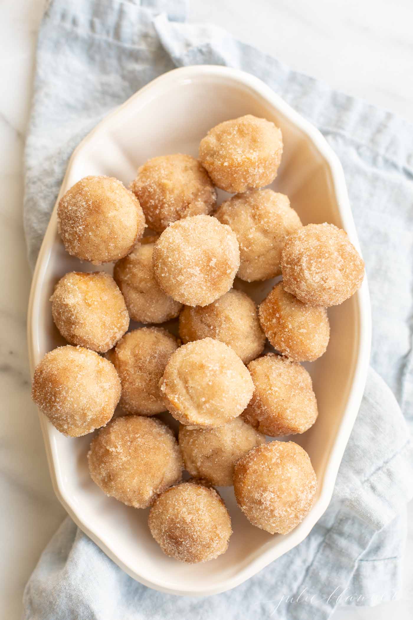 cinnamon sugar mini muffins in a white oval dish.