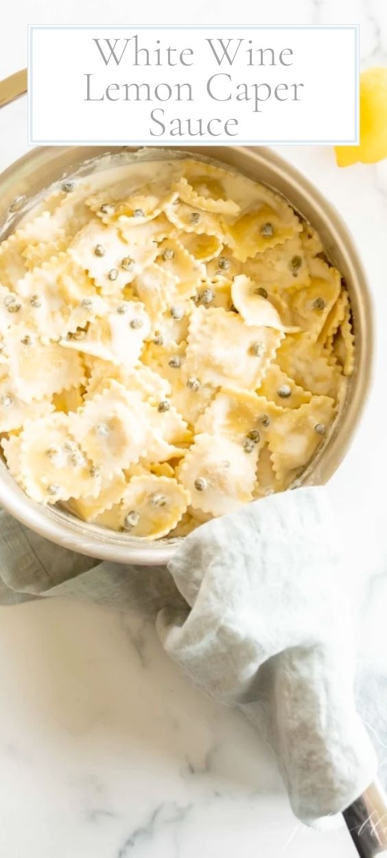 A stainless steel pan filled with ravioli in a white wine lemon caper sauce.