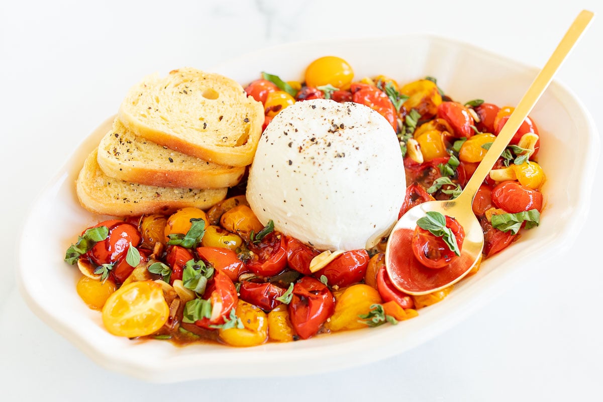 Platter of blistered tomatoes with crostini and burrata