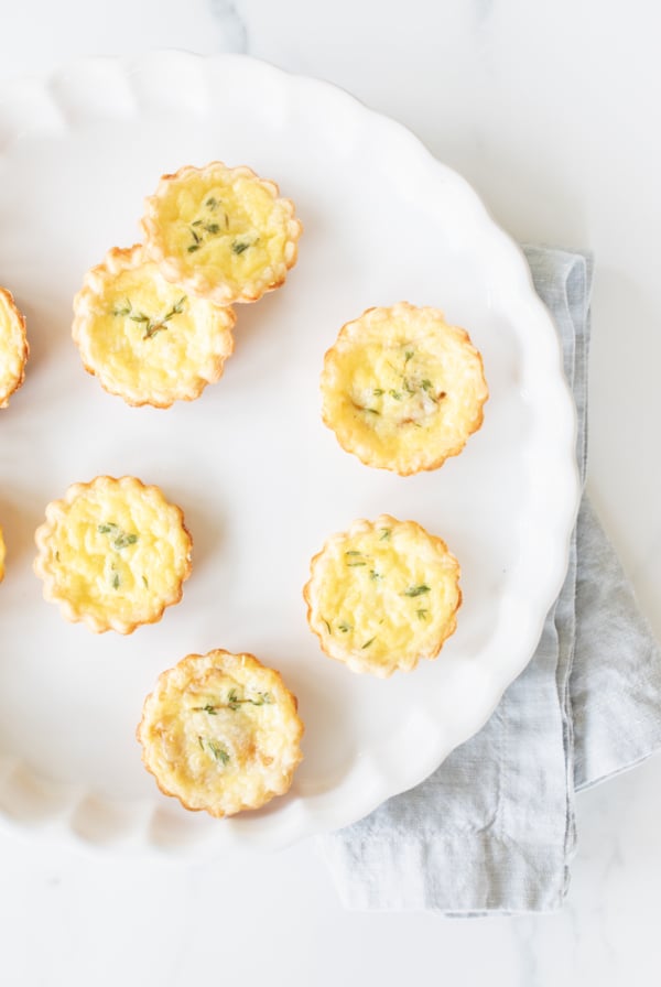 Mini quiches on a white plate with a napkin for Mother's Day brunch.