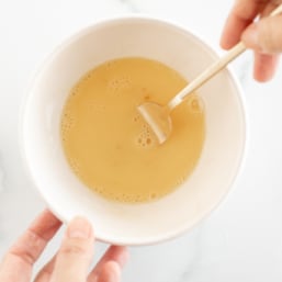 Whisking egg wash in small bowl with fork