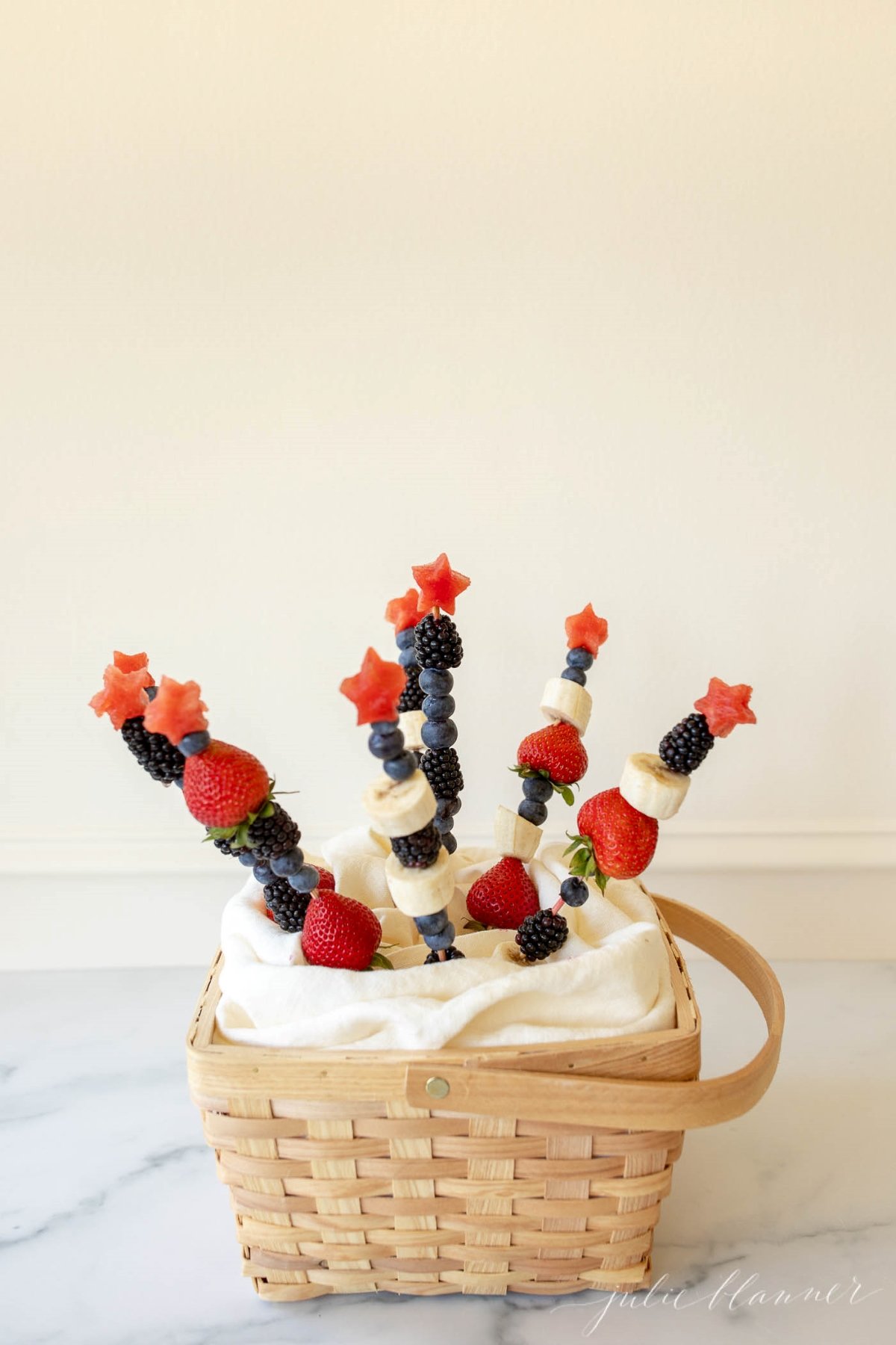 A basket full of patriotic fruit skewers