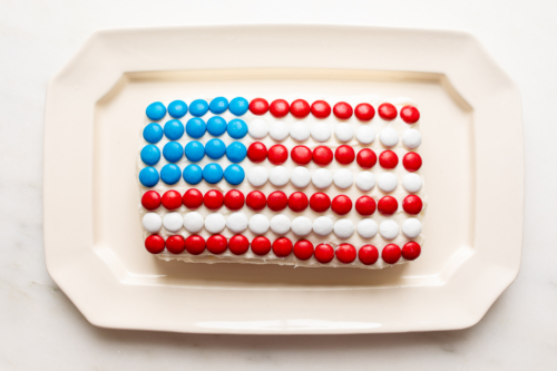 A red white and blue snack made of funfetti dip with patrioic m&ms on top.