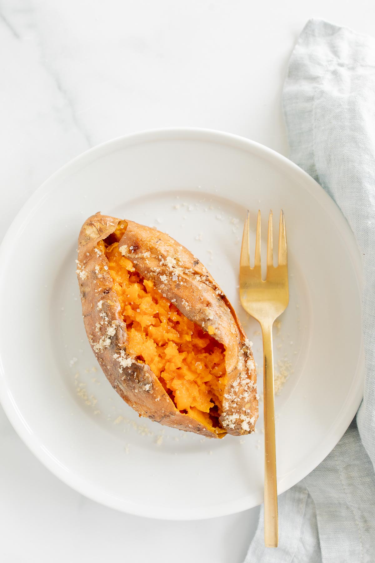 A grilled sweet potato on a white plate.