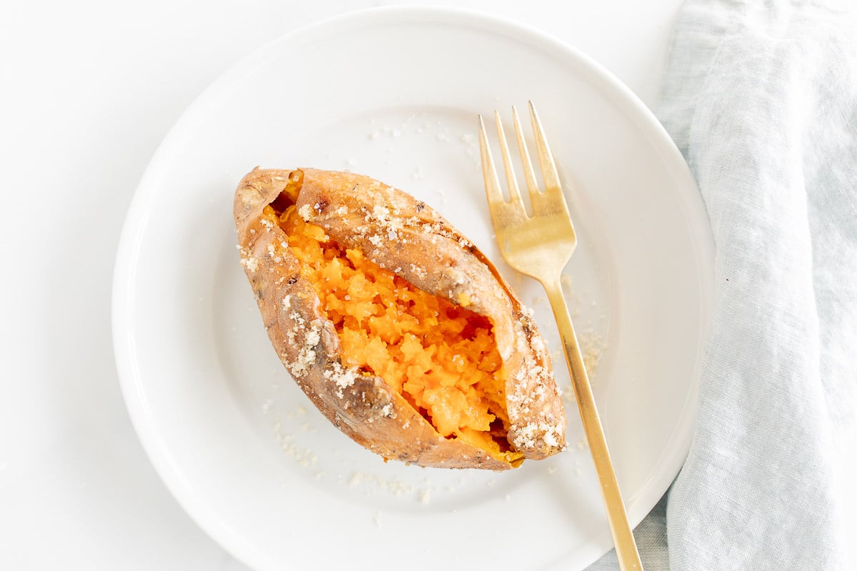 A grilled sweet potato on a white plate.