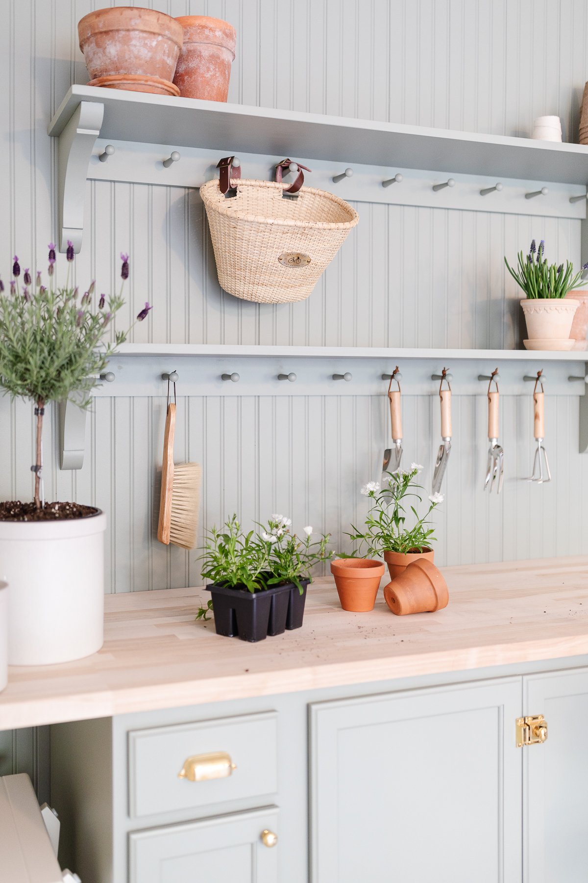 A garden bench and shelf with peg board, painted in sage green paint color.