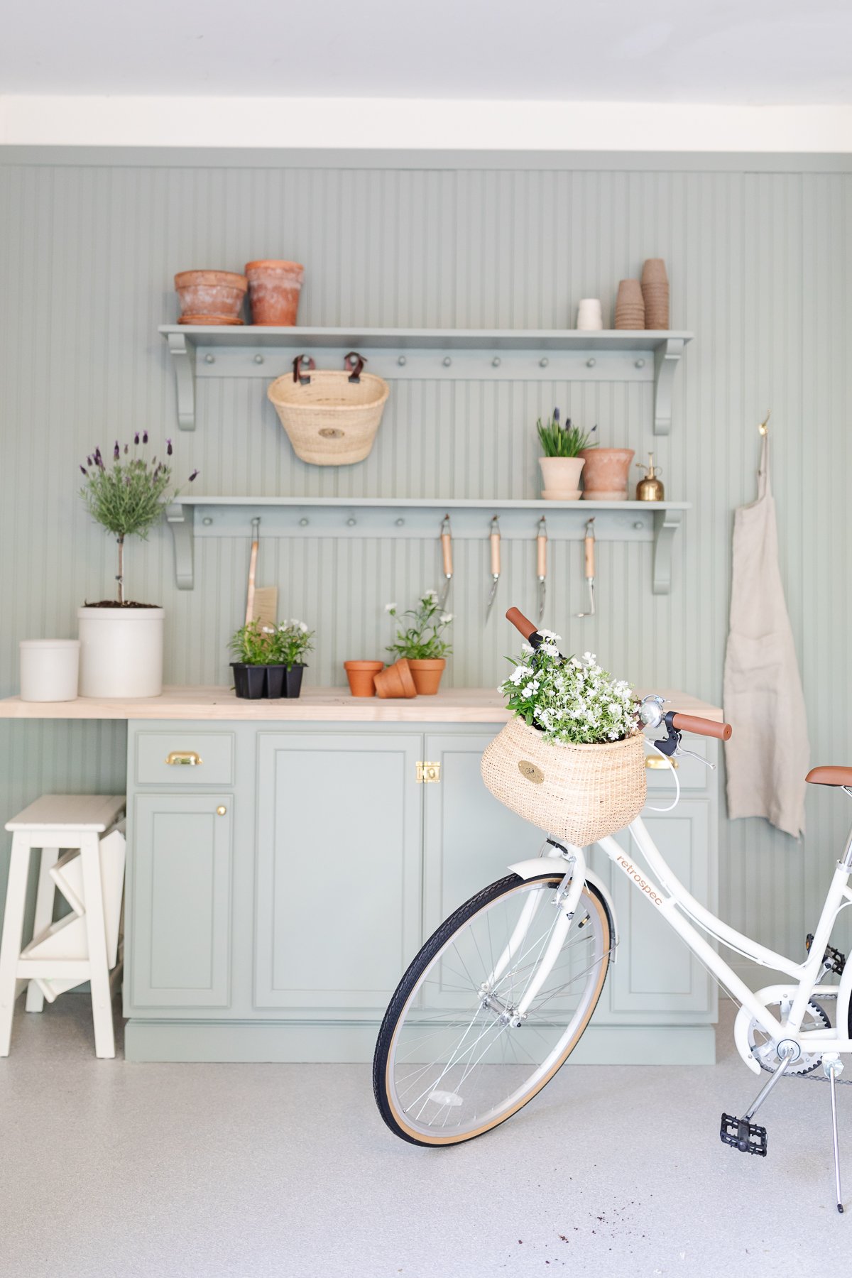 A garden bench and shelf with peg board, painted in sage green paint color.