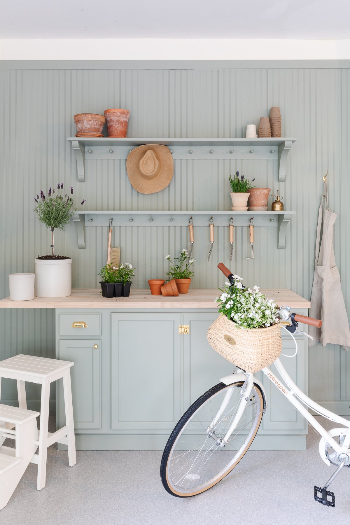 A garden bench and shelf with peg board, painted in sage green paint color.