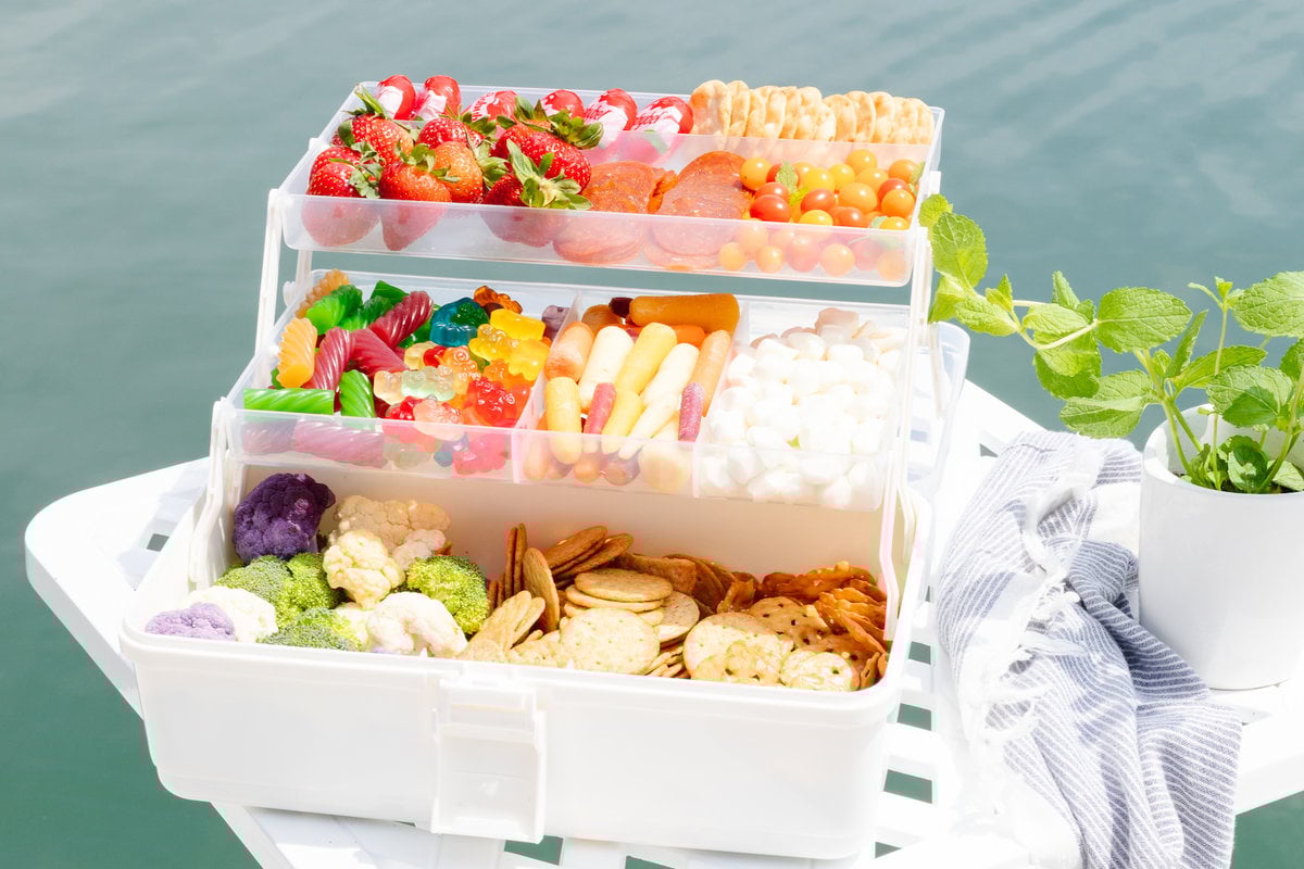 A snackle box on a white table with water in the background.