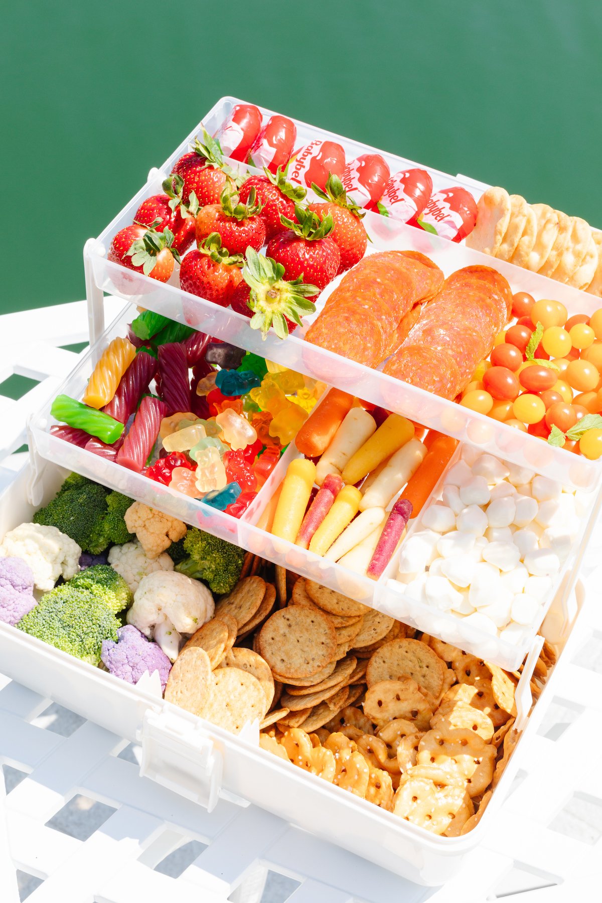 A snackle box on a white table with water in the background.