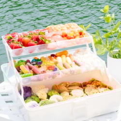A snackle box on a white table with water in the background.