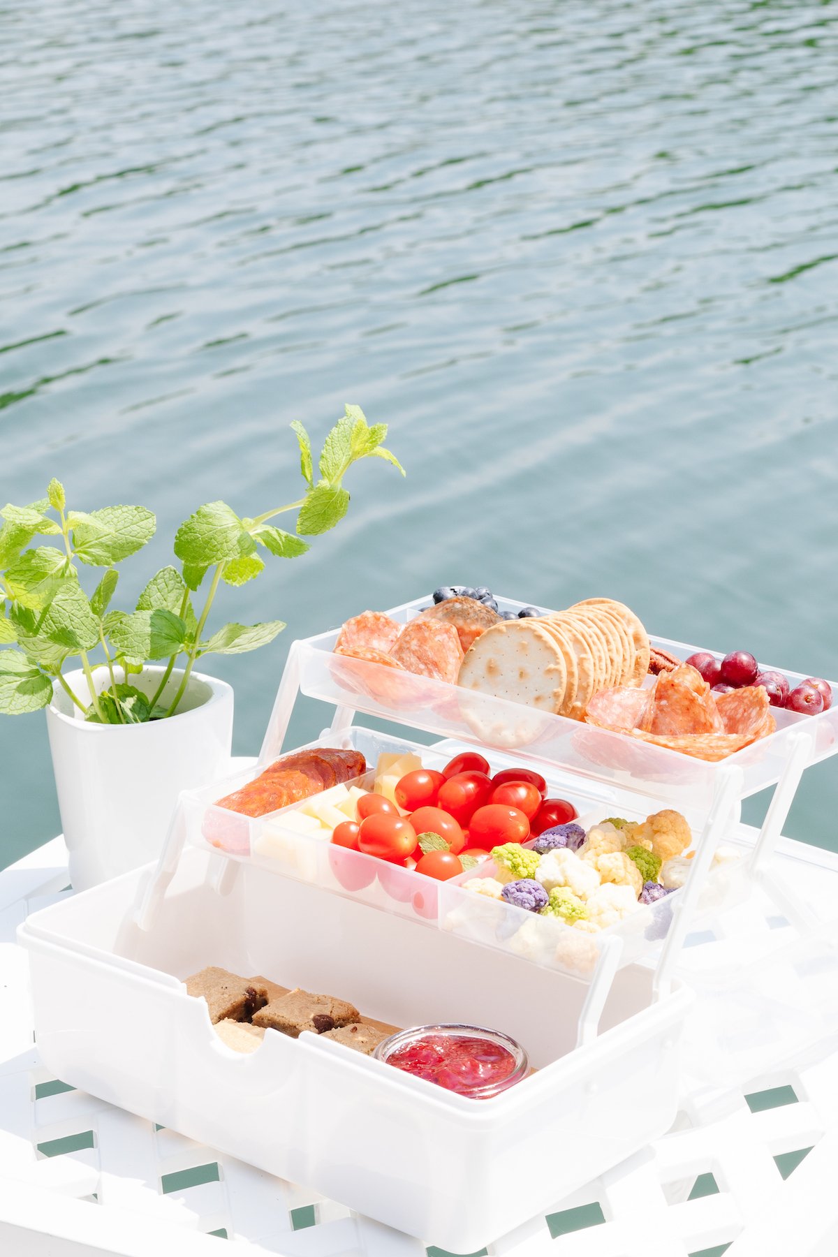 A snackle box on a white table with water in the background.