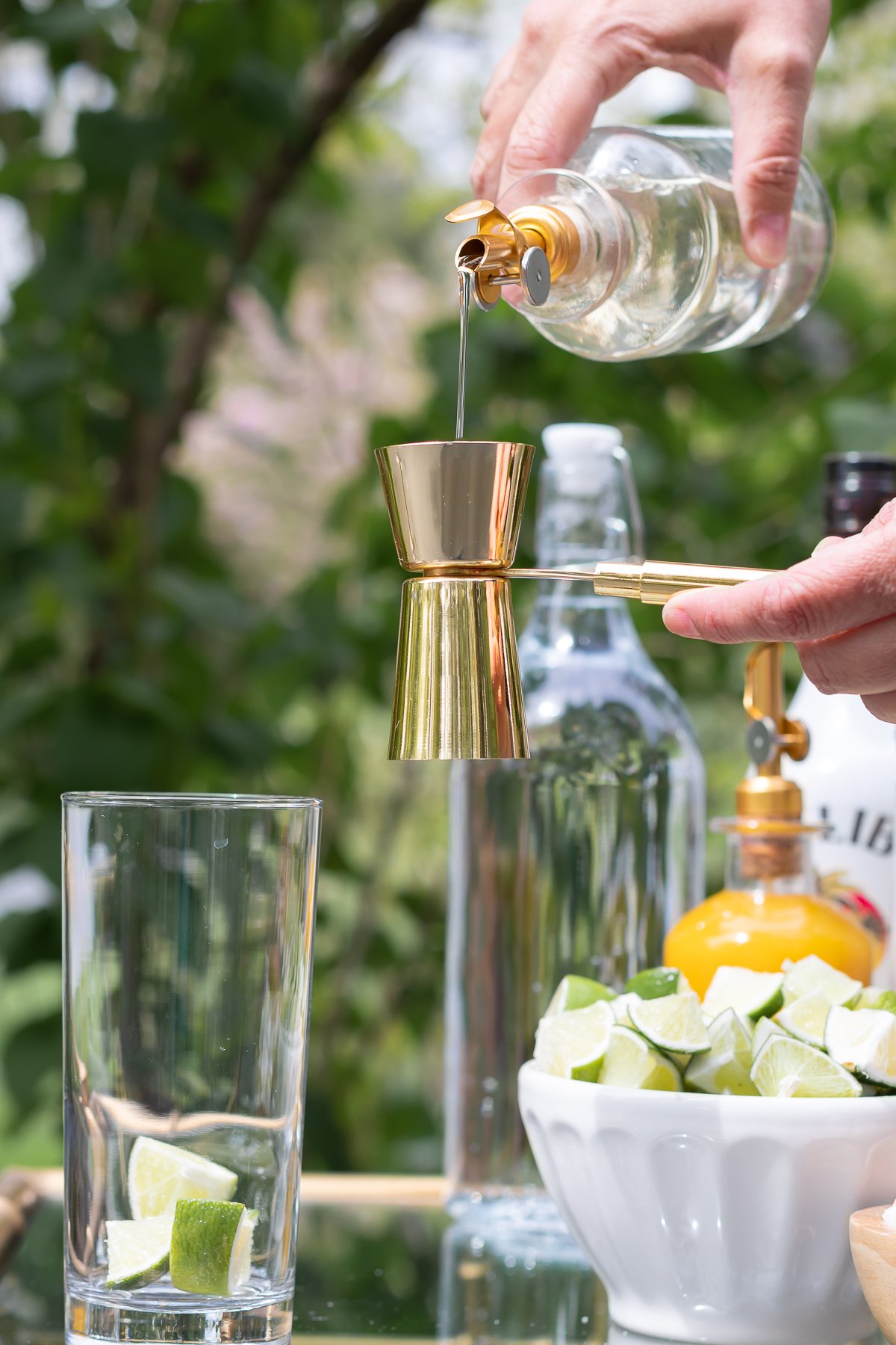 Pouring bottle of pineapple simple syrup to make cocktail