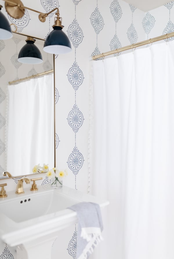 A bathroom with navy blue and white block print wallpaper.