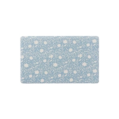 A blue and white bathroom mat with flower designs that doubles as an anti-fatigue kitchen mat.