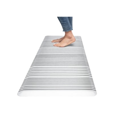 A person standing on an anti-fatigue kitchen mat.