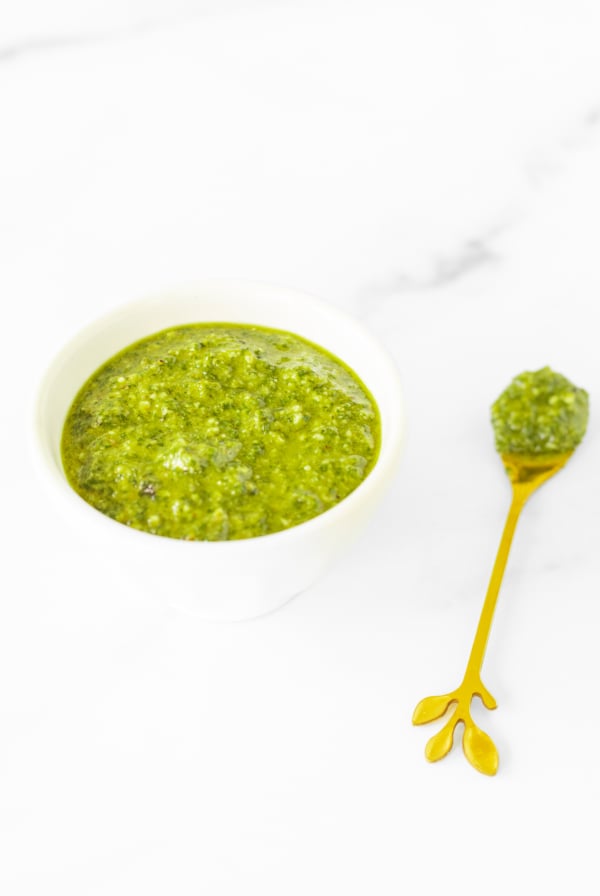 Walnut pesto in a white bowl on a marble countertop.