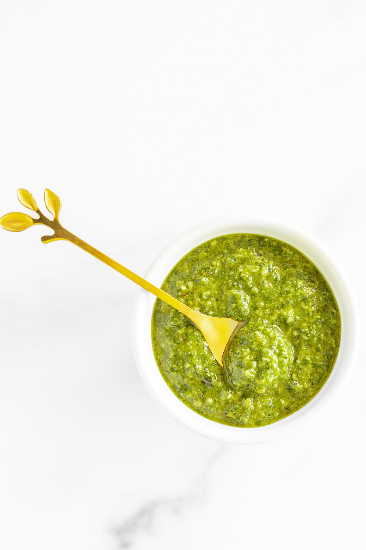 Walnut pesto in a white bowl on a marble countertop. 
