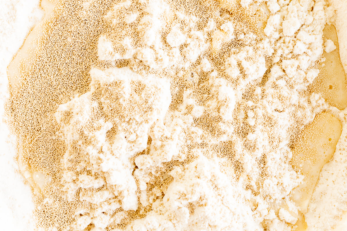 A close up of flour in a bowl, ready to be used for making apple cinnamon rolls.