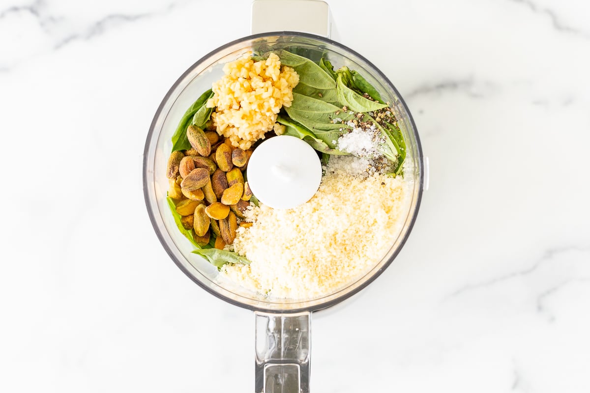 A food processor filled with Pistachio Pesto ingredients.