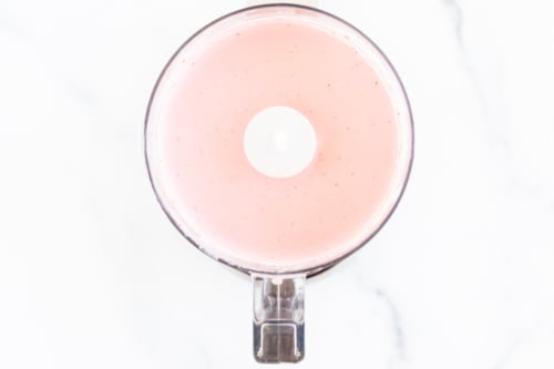 Strawberry cream cheese inside a food processor.