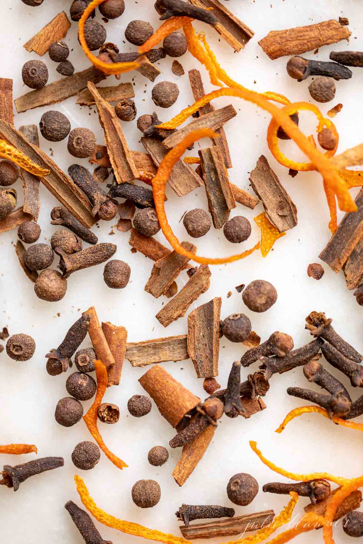 A pile of mulling spices on a white surface.