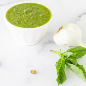 A bowl of pistachio pesto sauce with garlic and basil.