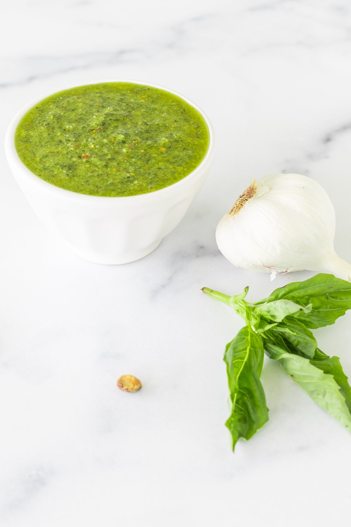 A bowl of pistachio pesto with garlic and basil.