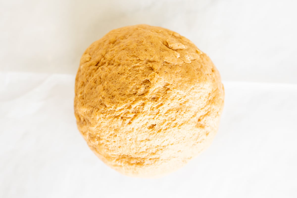 A Pumpkin Cinnamon Roll sitting on a white surface.